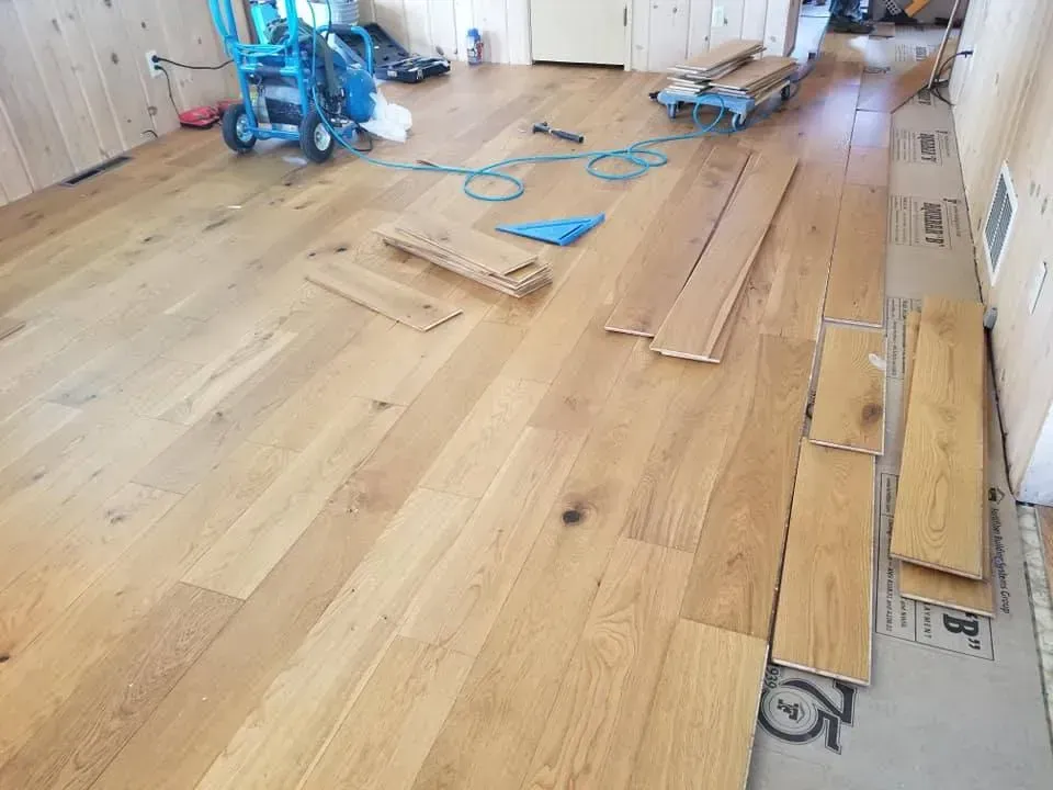 A wooden floor is being installed in a room.