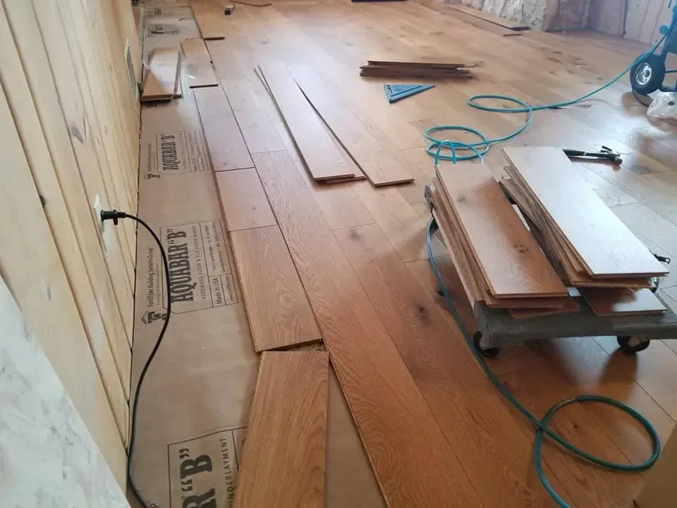 A wooden floor is being installed in a room