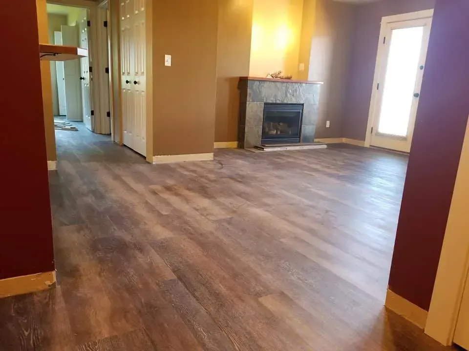 A living room with hardwood floors and a fireplace.