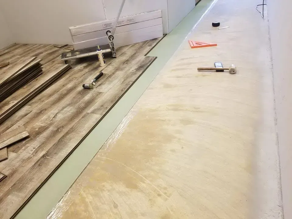 A wooden floor is being installed in a room.