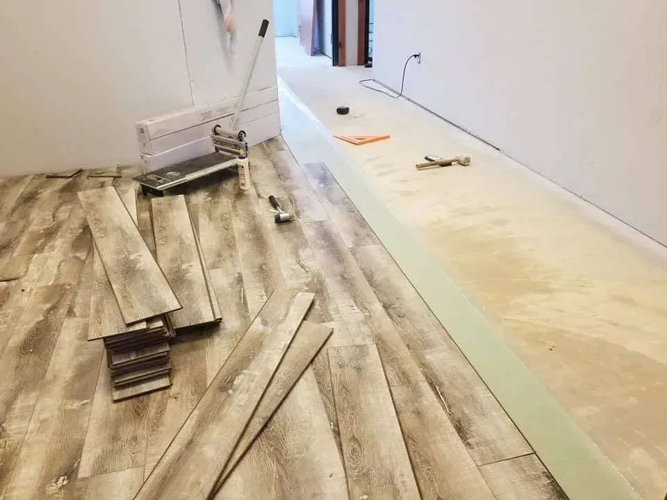 A wooden floor is being installed in a room.