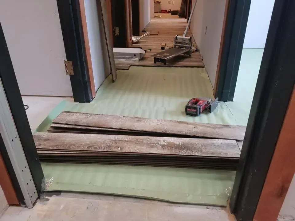 A wooden floor is being installed in a hallway.