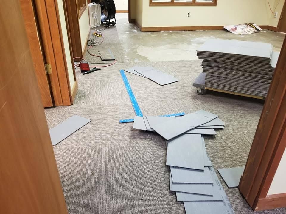 A room with a stack of cardboard boxes on the floor.