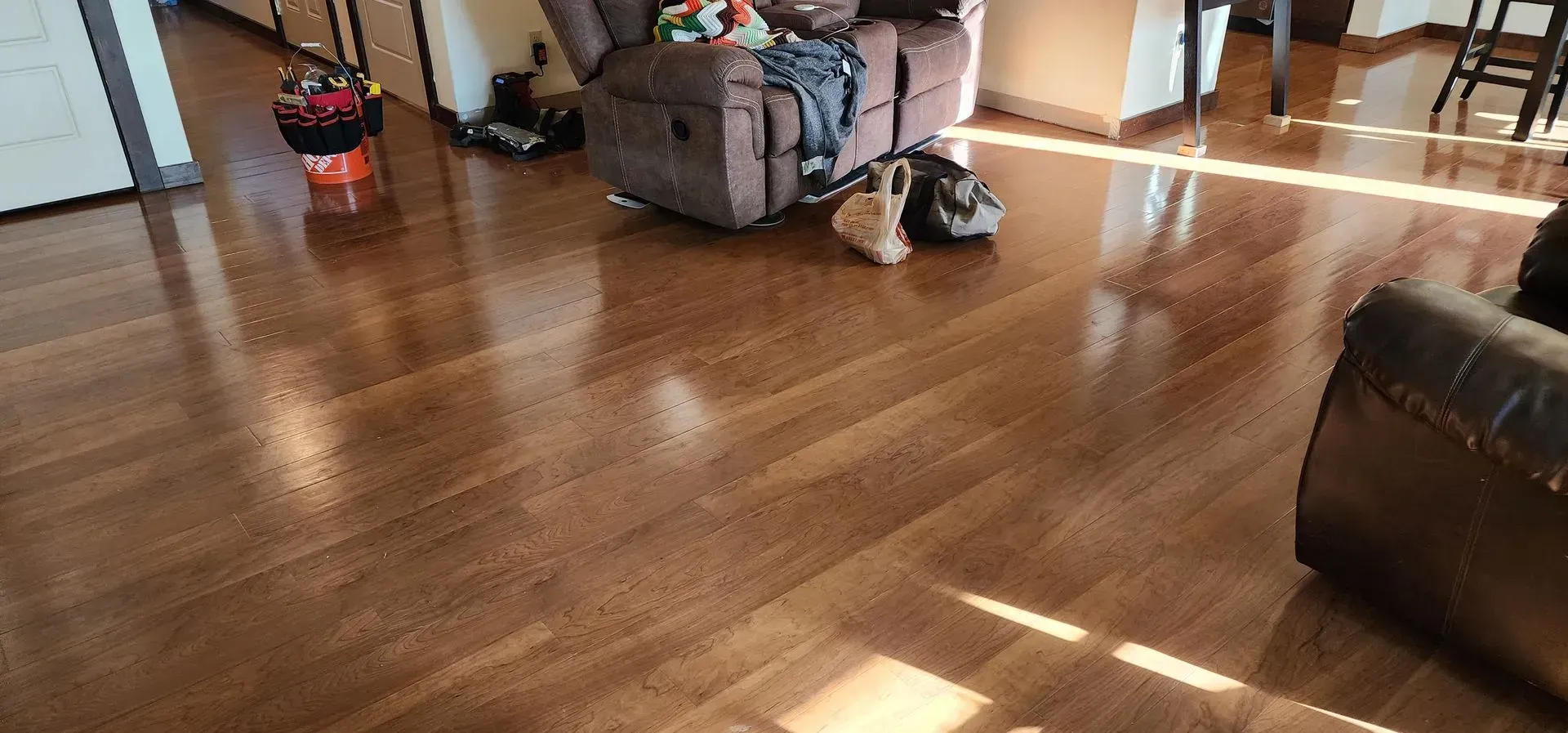 A living room with hardwood floors , a couch , and a chair.