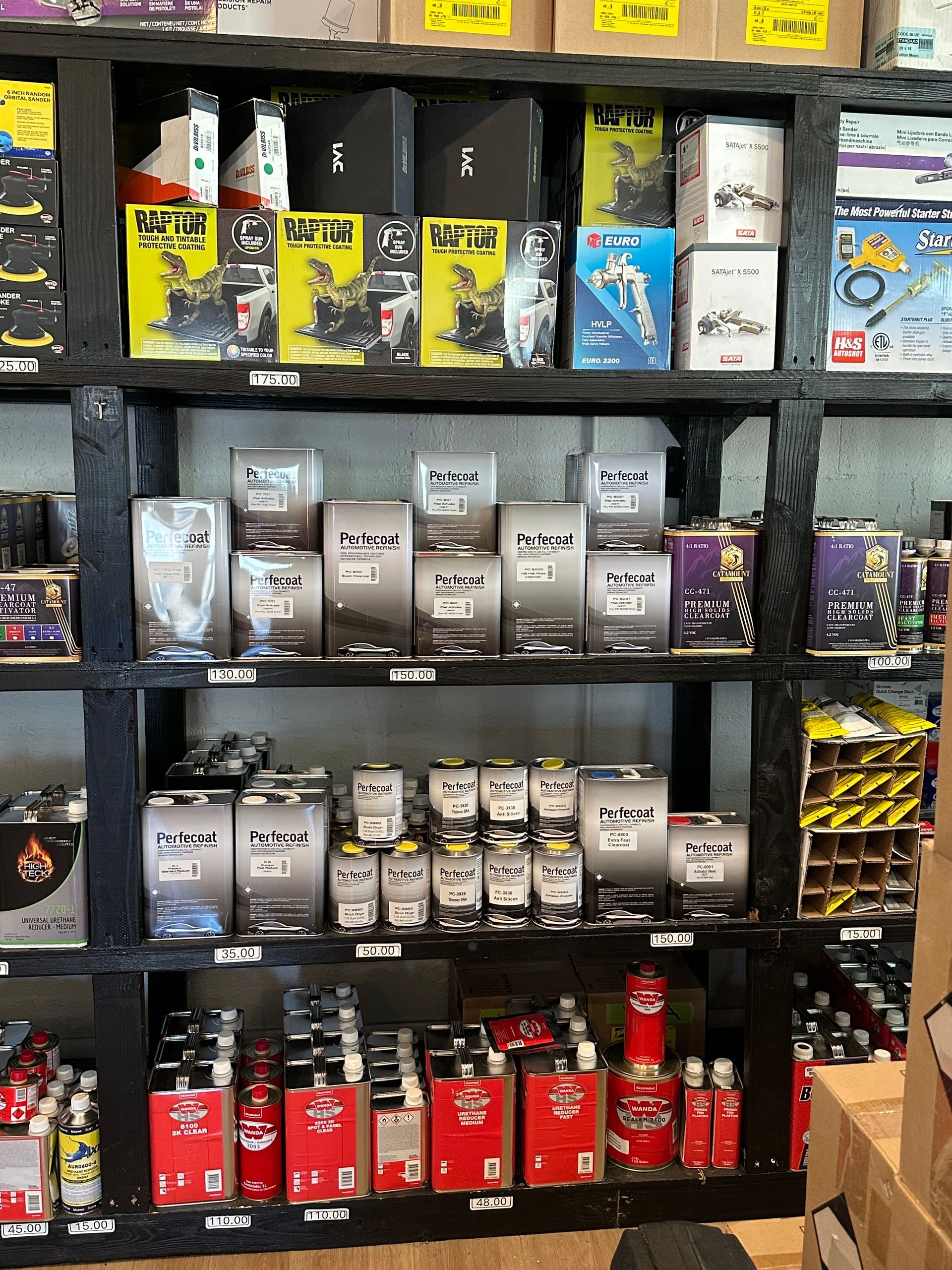 Three cans of paint are sitting next to each other on a shelf.