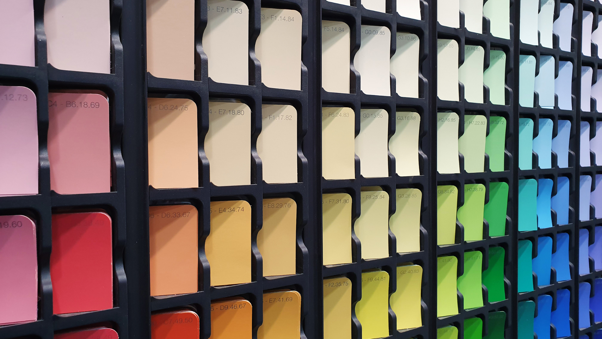 A wall filled with lots of different colored paint samples