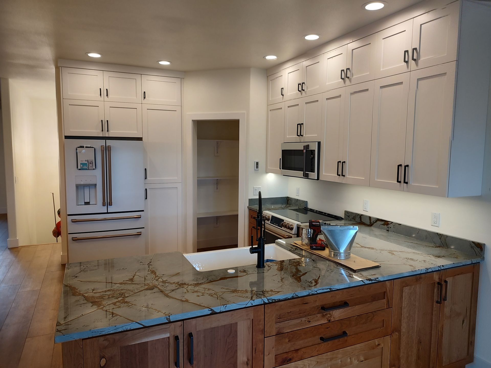 A kitchen with white cabinets and granite counter tops