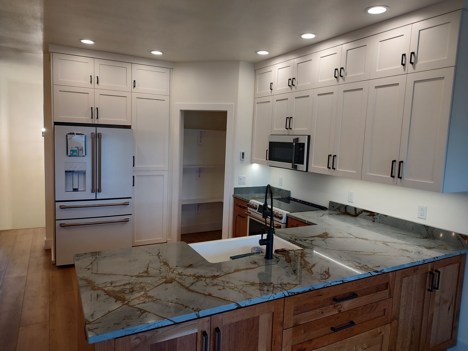 A kitchen with white cabinets and granite counter tops
