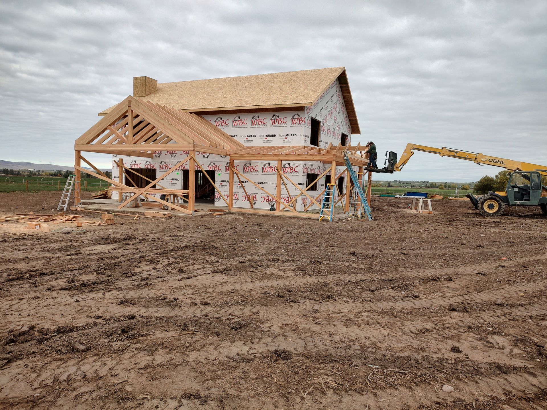 A house is being built in a dirt field.