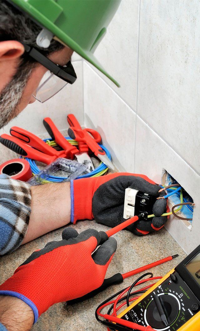 Electrician With Gloves and Safety Instruments Fixes The Electric Cable — Jason Wenta Electrical Services in Condon, QLD