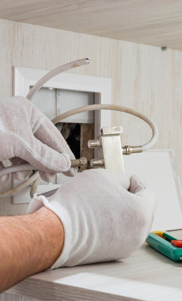 Worker Inserts Connector of a TV Antenna — Jason Wenta Electrical Services in Condon, QLD