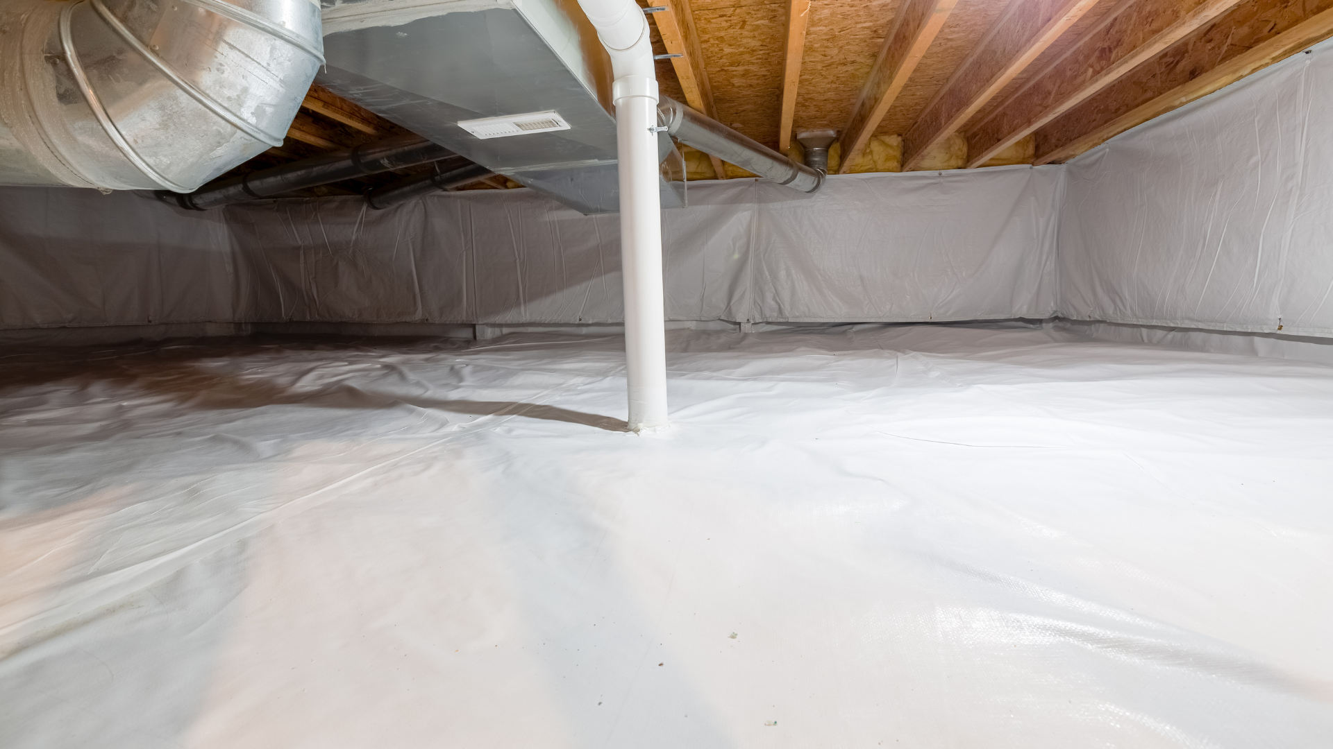 White crawlspace with insulation on walls and floor; exposed wooden beams.