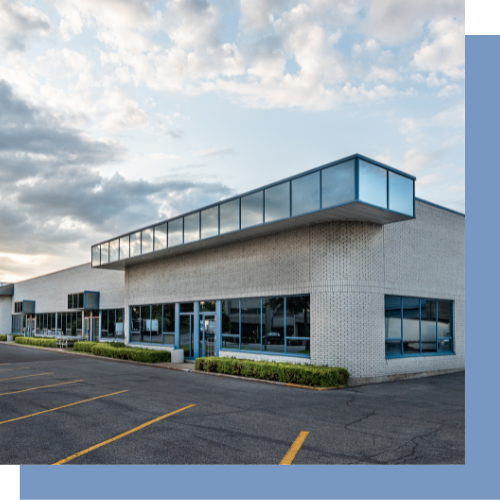 a large brick building with a lot of windows and a parking lot in front of it .