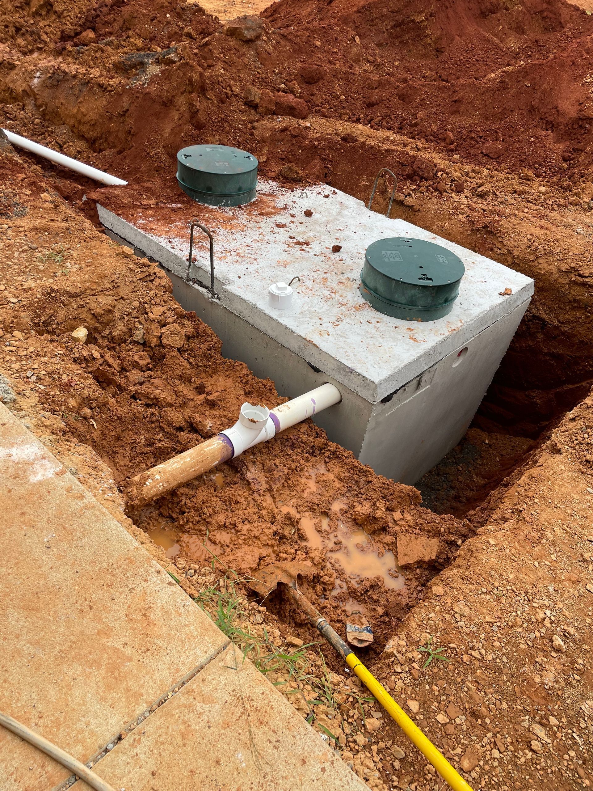 A septic tank is being installed in a hole in the ground.