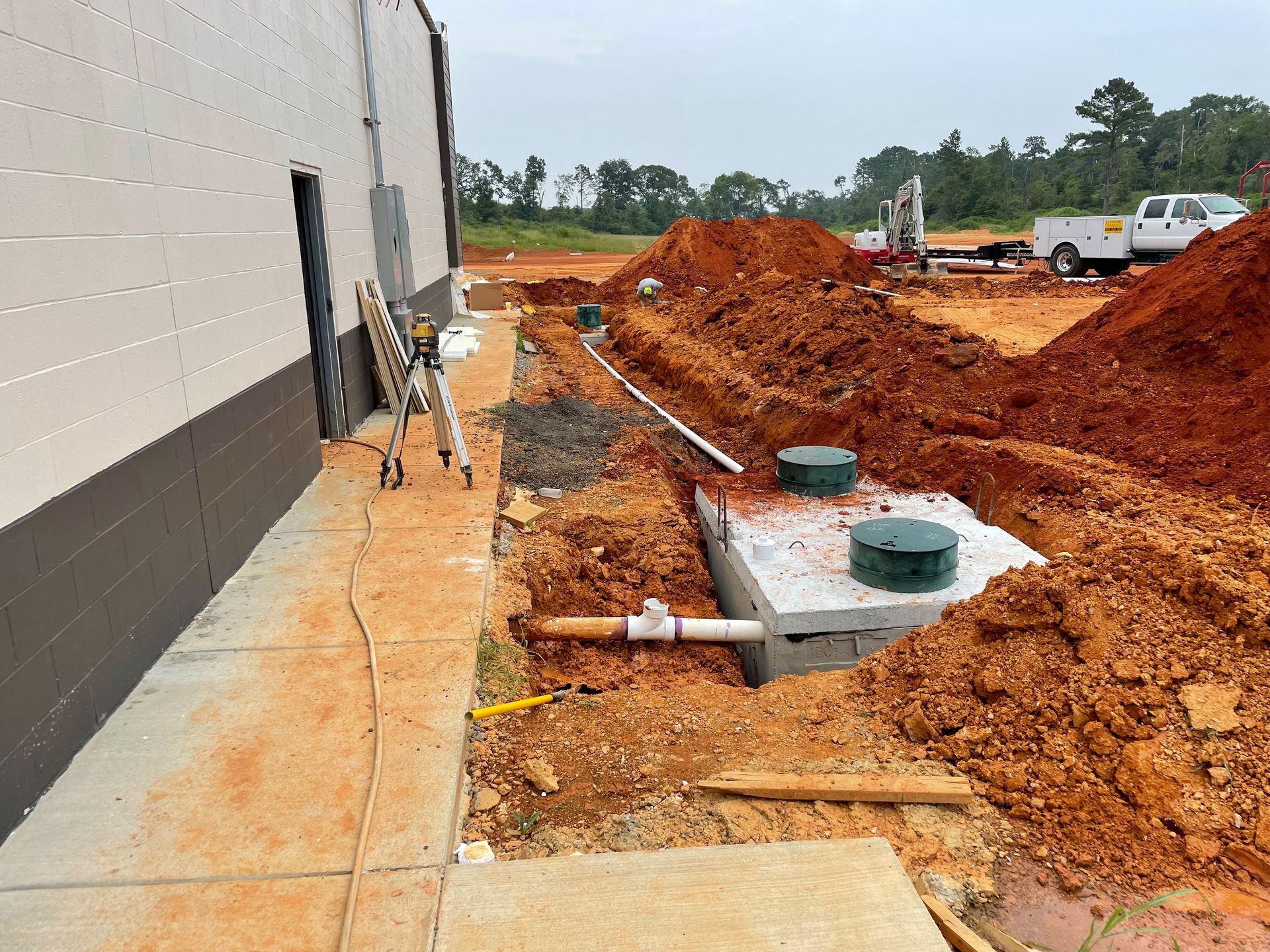 A large pile of dirt is sitting in front of a building under construction.