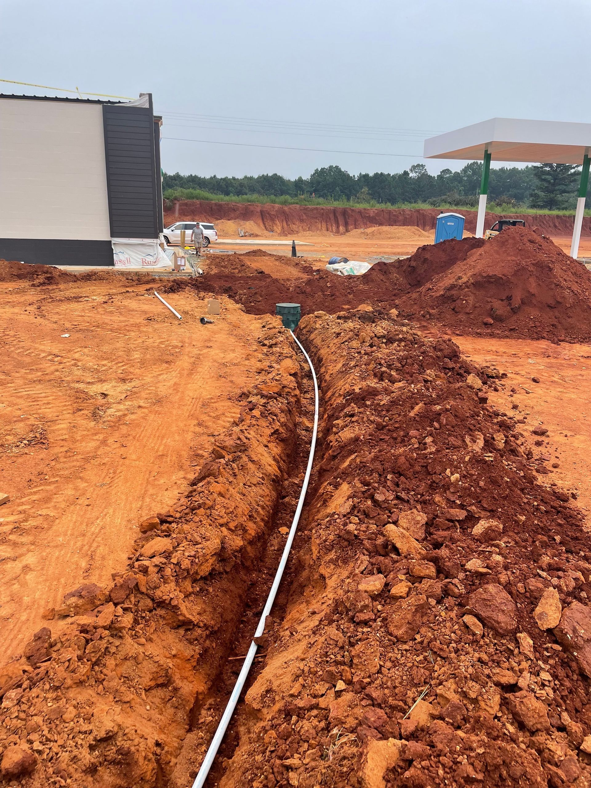 A white wire is laying in the dirt in a construction site.