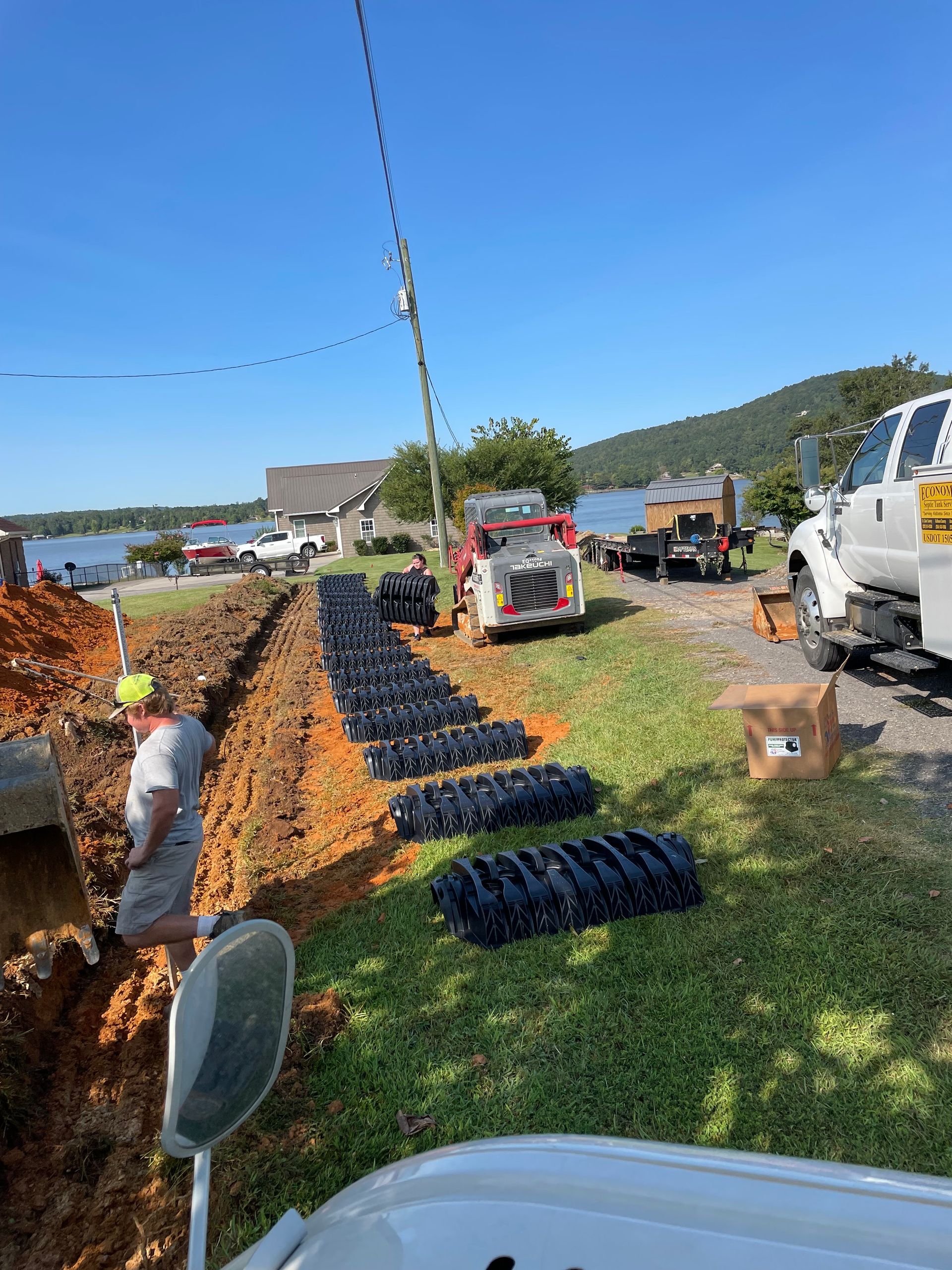 A man is digging in the dirt next to a truck.