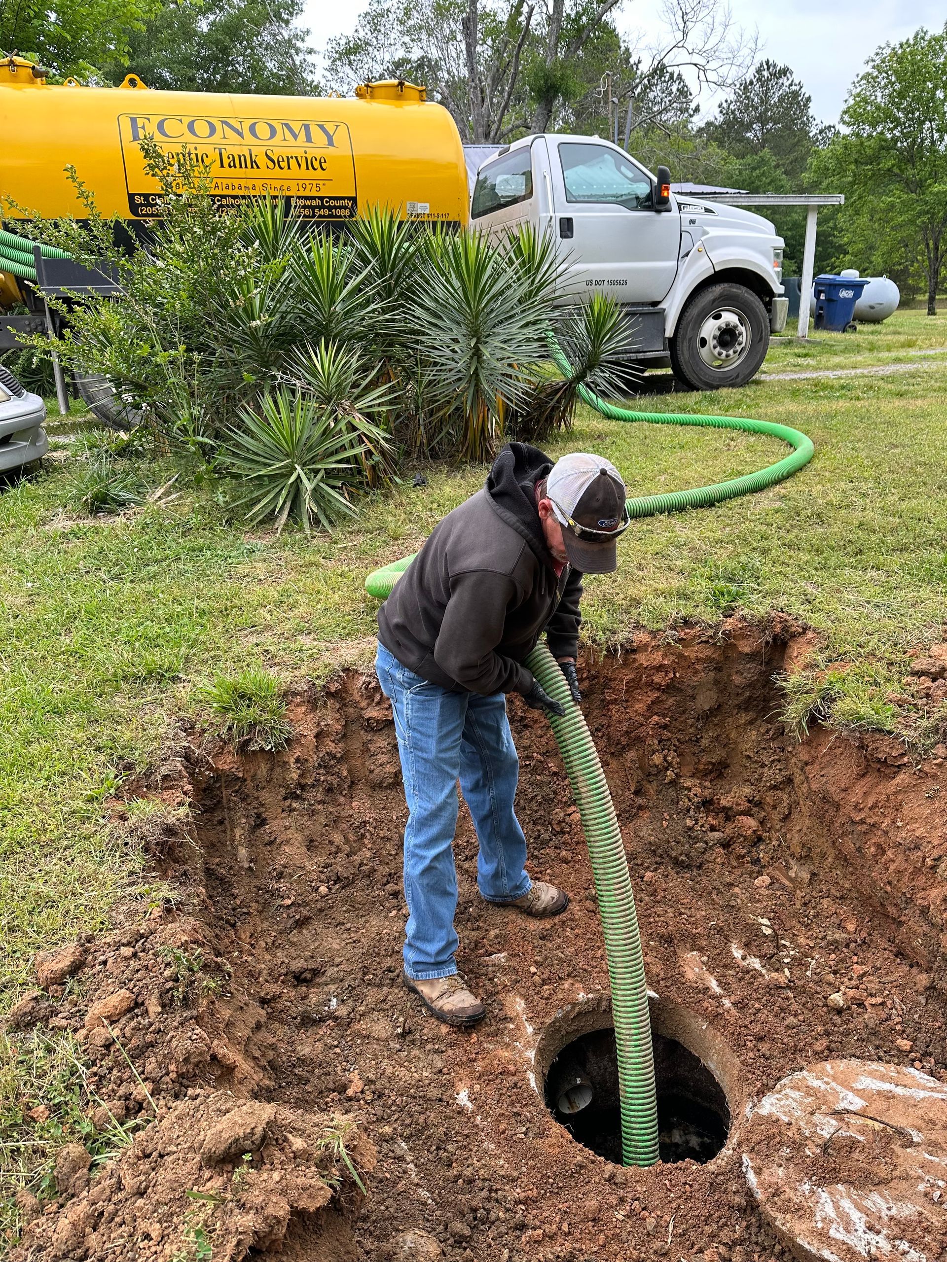A man is pumping water into a septic tank.