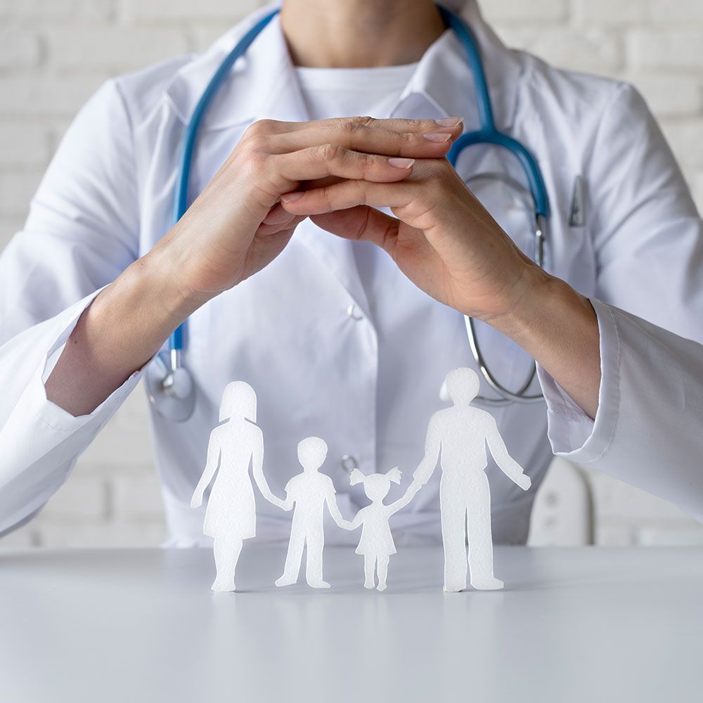 A doctor is holding a paper cut out of a family.