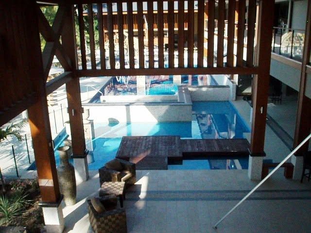Covered outdoor pool with lounge chairs and a shaded seating area overlooking the water
