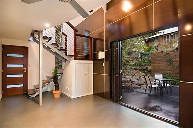Modern interior with staircase, white cabinet, and large sliding glass door opening to a patio