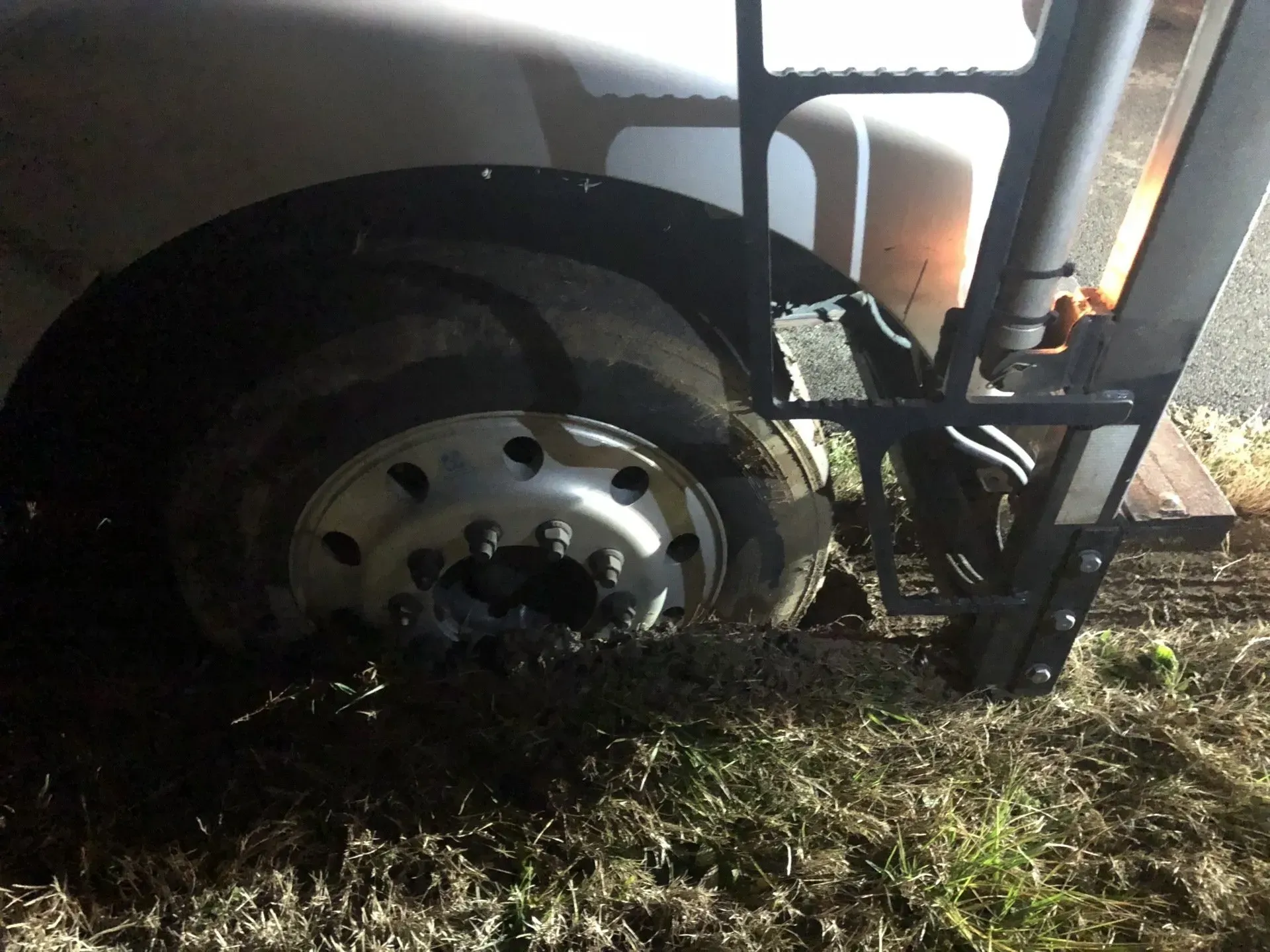 A close up of a truck wheel with a ladder attached to it.