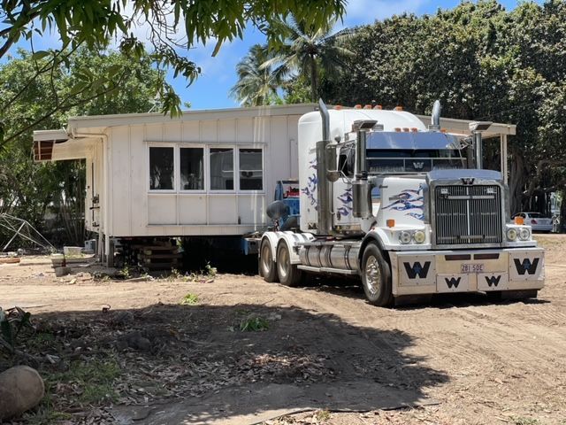 A  White Semi Truck Is Carrying a House on A Trailer — Conan The House Lifter In Townsville, QLD