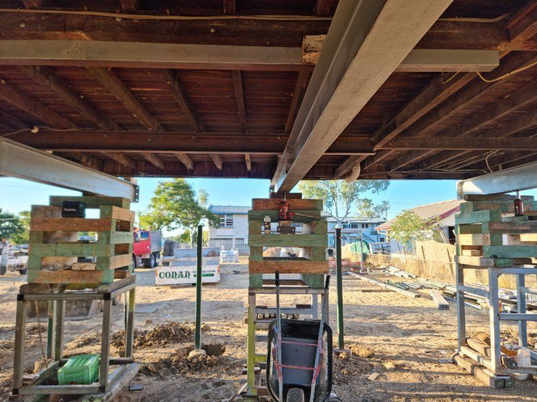 A Building Under Construction with Wooden Pallets and A Wheelbarrow — Conan The House Lifter In Townsville, QLD