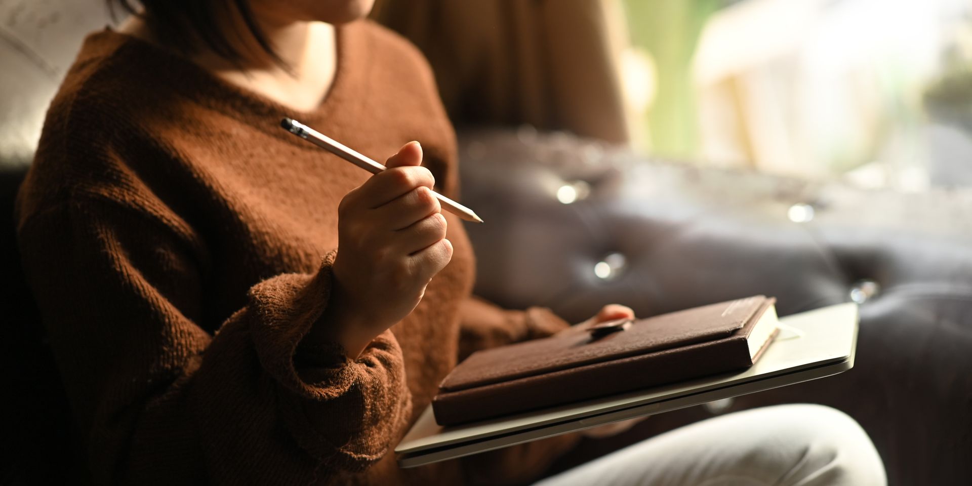 Person writing in a journal in a calm space representing emotional processing and healing