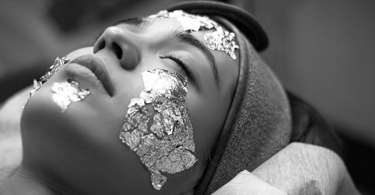 Uma mulher está deitada com uma máscara de alumínio no rosto.