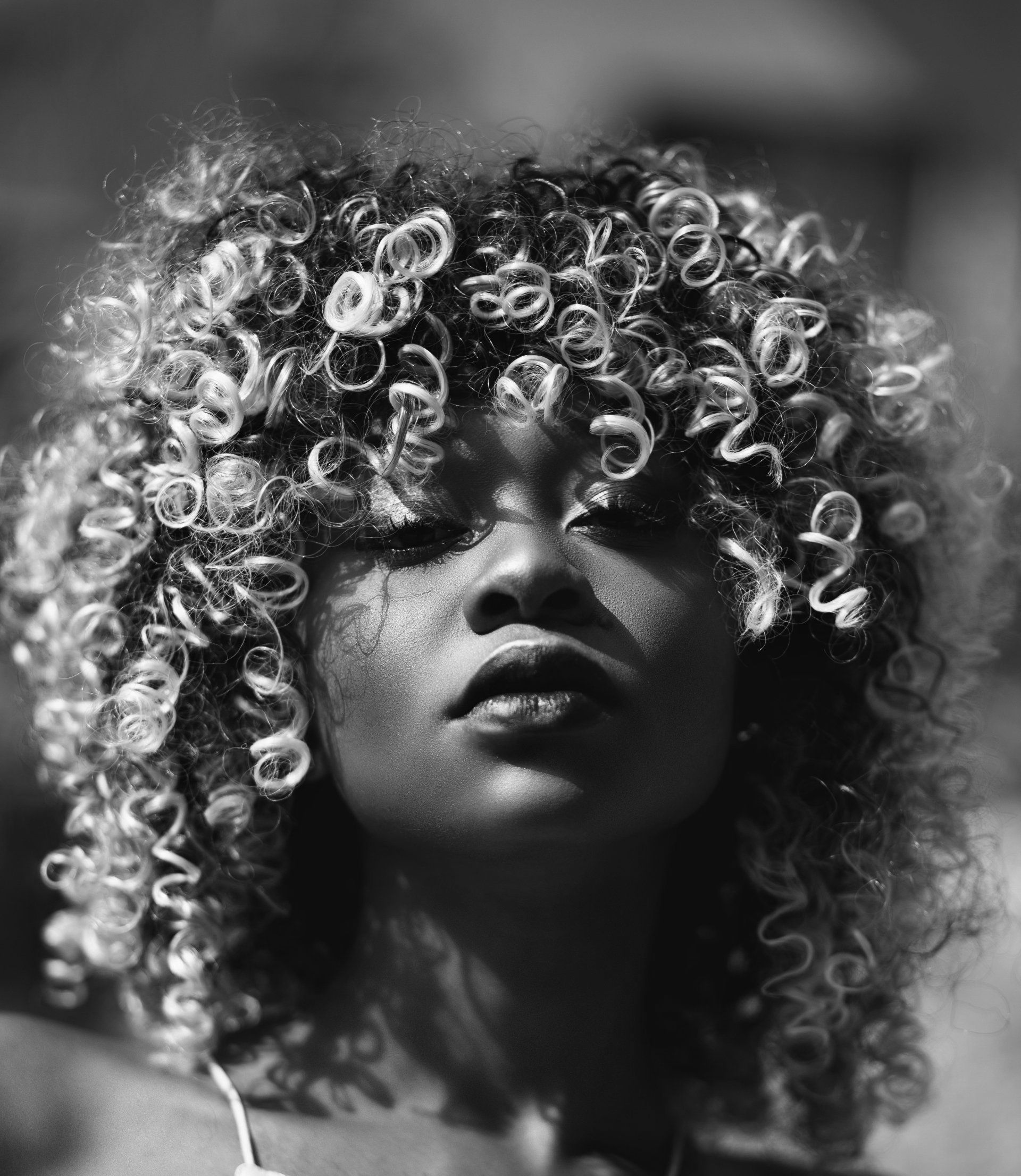 Uma foto em preto e branco de uma mulher com cabelos cacheados.