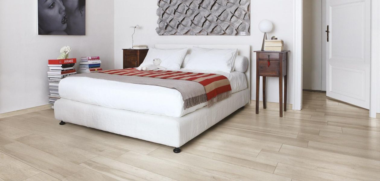 camera da letto con parquet in legno chiaro
