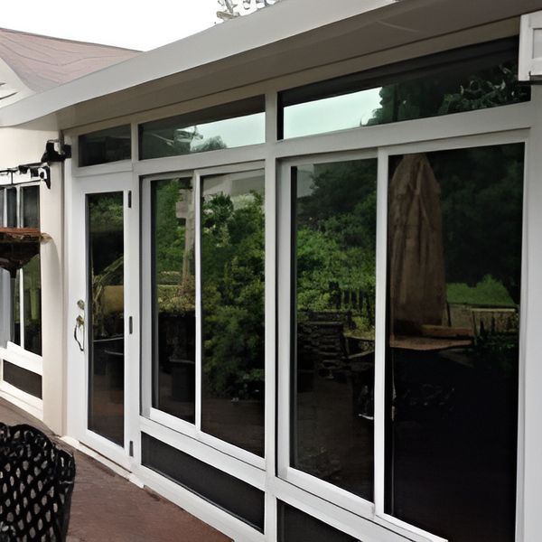 A House With A Lot Of Windows And Sliding Glass Doors — A & C Classic Window Tinting In Cessnock, NSW