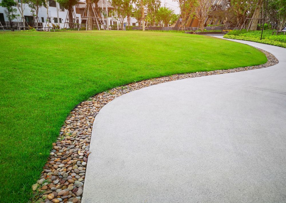 Curved Walkway Borders Green Grass, With a Row of Small Stones — Restoradrive in Banora Point, NSW