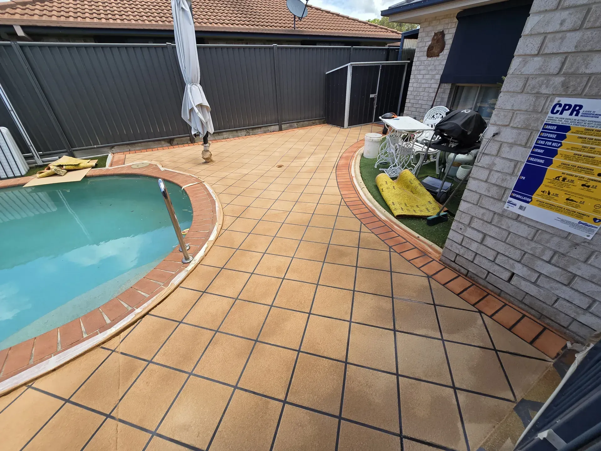 Stamped concrete patio with a small table, in sunlight.