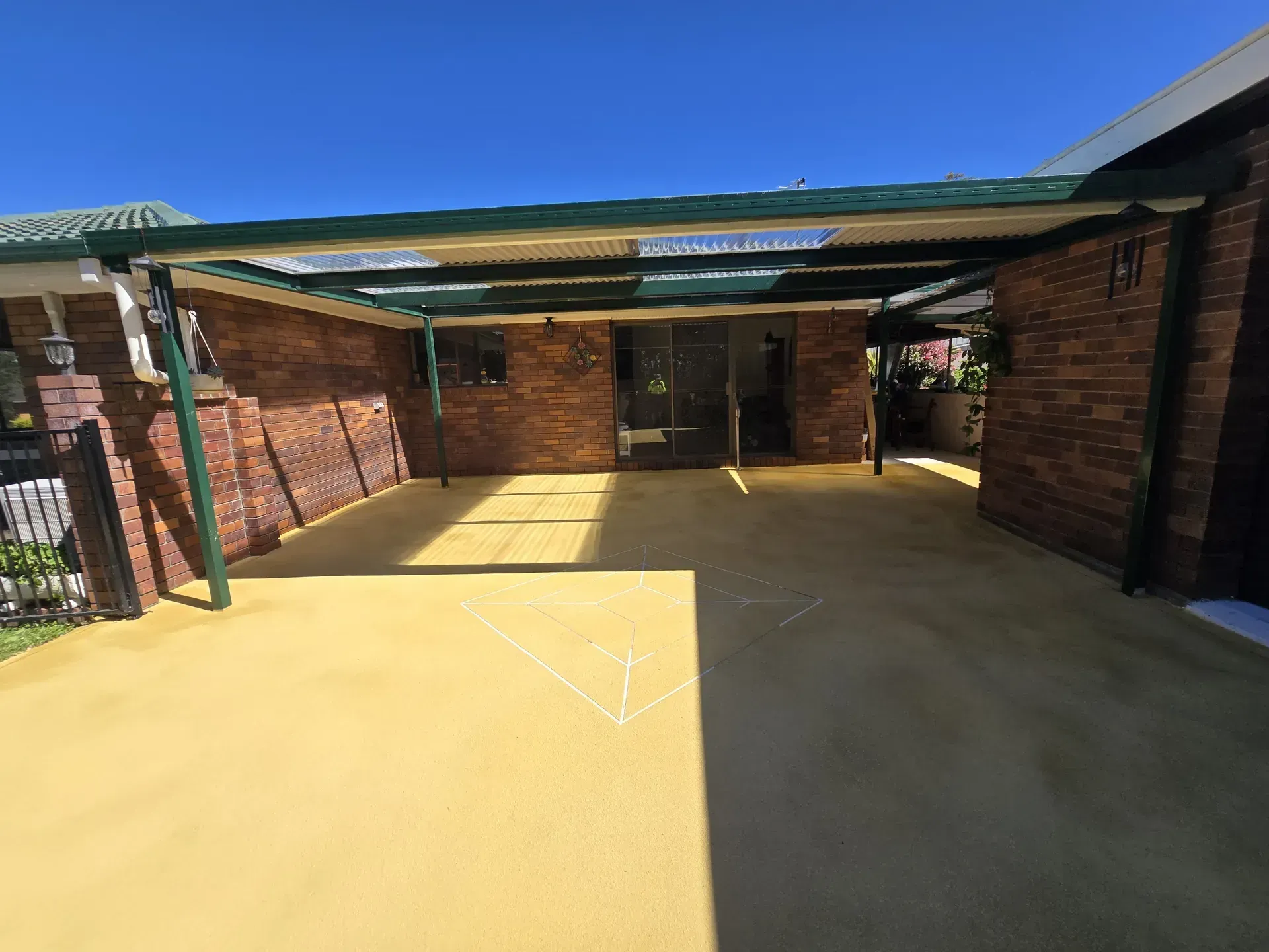 Two-car garage with bright blue doors, light yellow walls, and a concrete driveway.