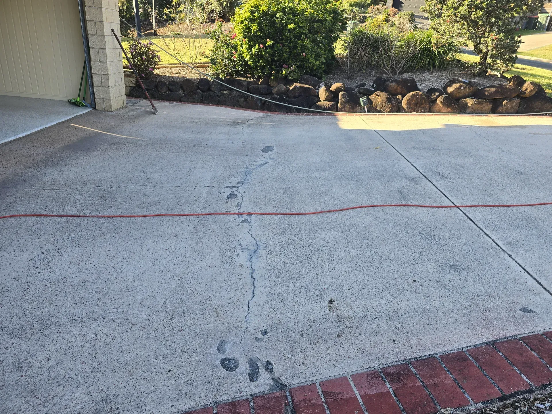 Two Construction Workers Leveling Wet Concrete With a Long Screed in an Outdoor Setting — Restoradrive in Ballina, NSW