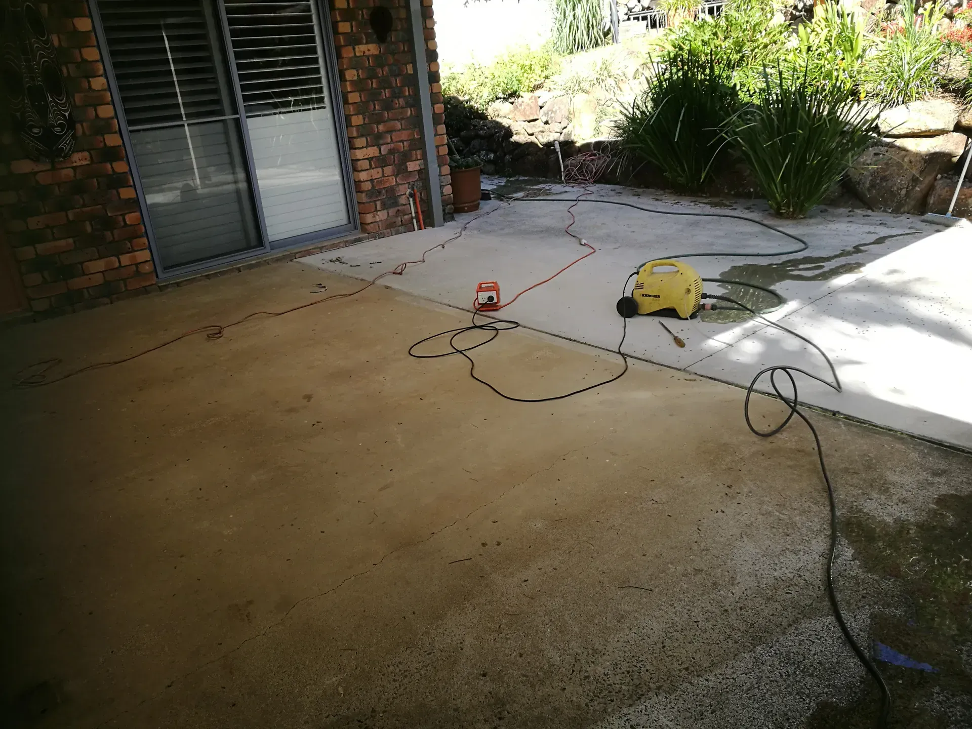 Stamped concrete patio with a small table, in sunlight.