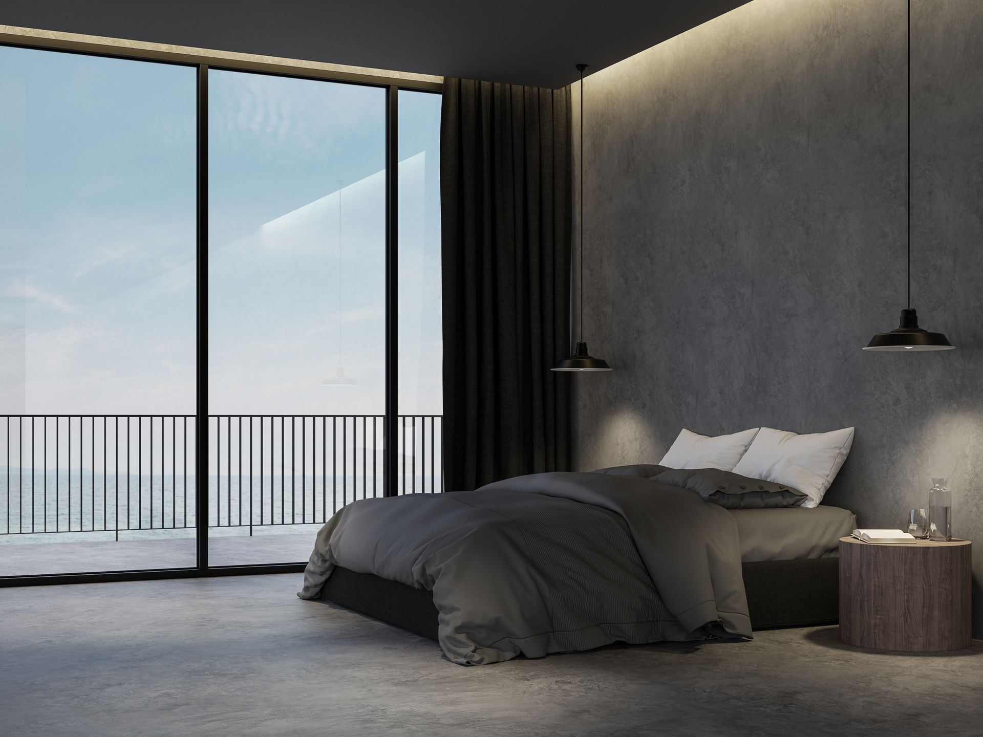 Bedroom with dark gray walls, bed, and floor. Large window with balcony overlooking the ocean. Black curtains and pendant lights.