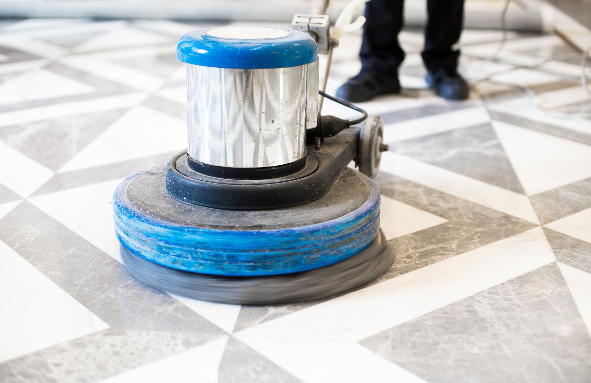 A person is using a machine to polish a tiled floor.