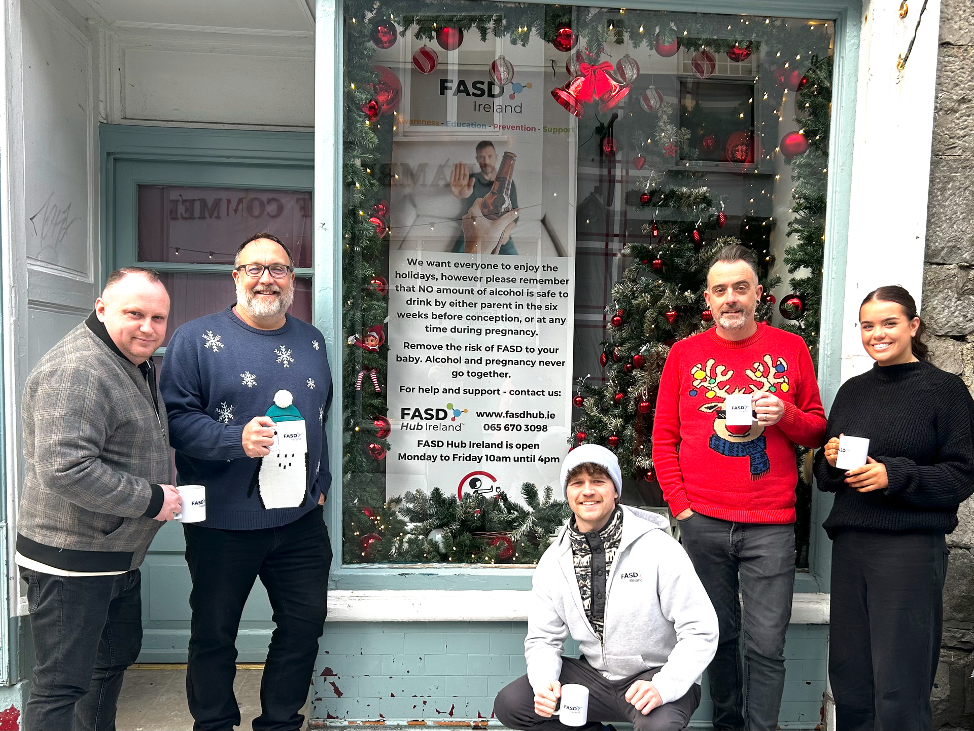 FASD Ireland Team outside offices in front of a Christmas themed window with new banner for 2024