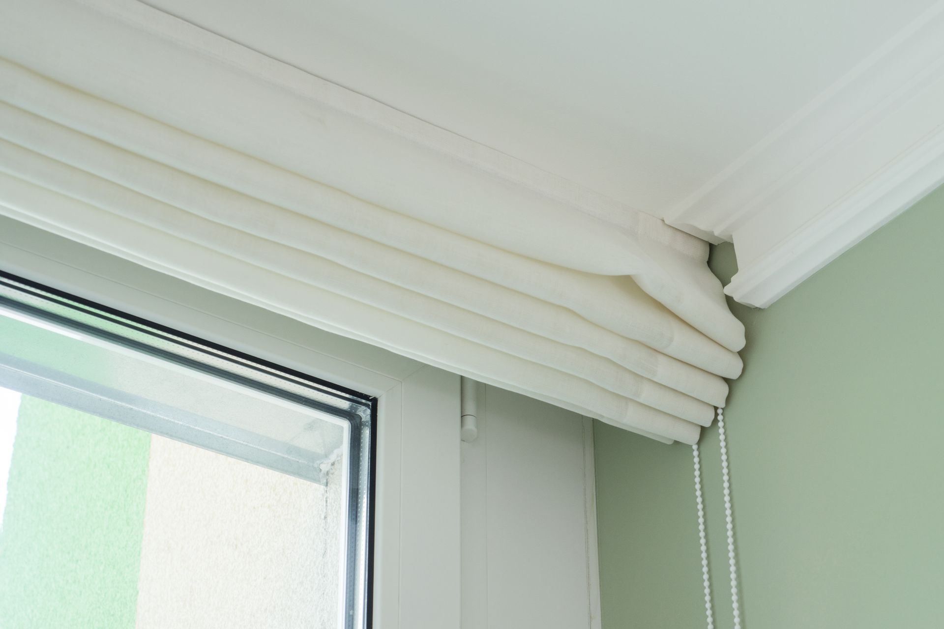 Gray curtains hanging from black rods in a corner of a room.