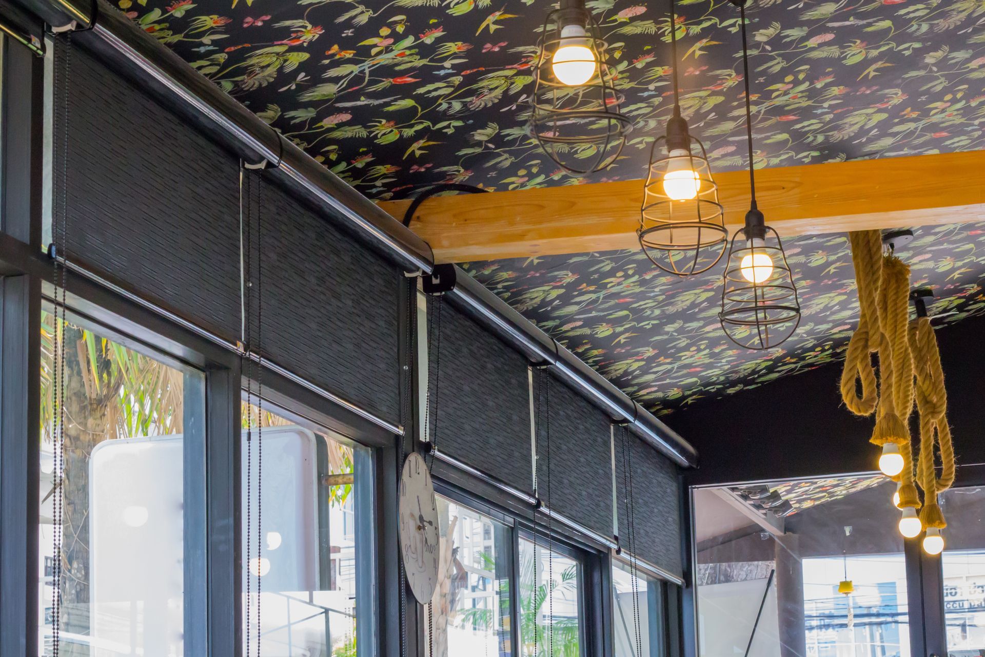 White sheer curtains hanging in front of a window, with wavy lower edge over a wooden floor.