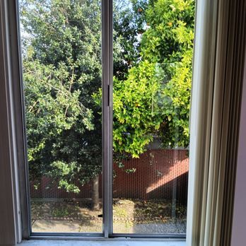 A sliding glass door with a view of trees and a fence.