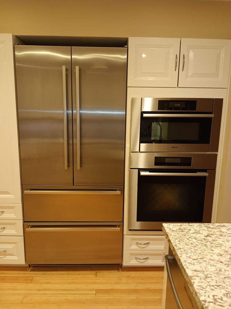 A kitchen with stainless steel appliances and white cabinets