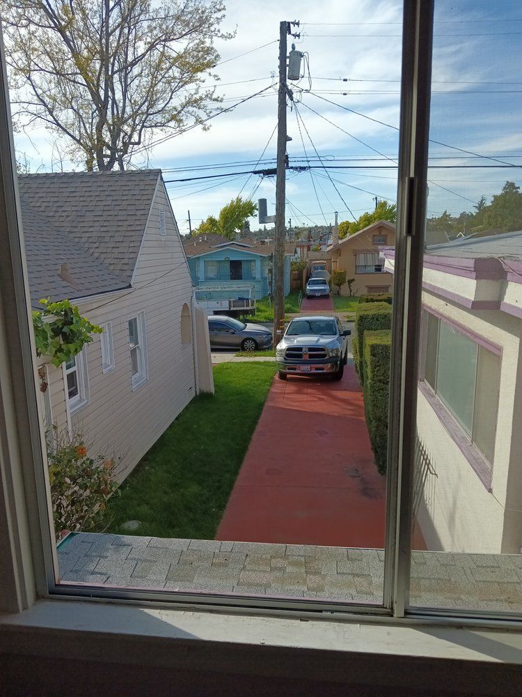 A car is parked on the side of the road next to a house.