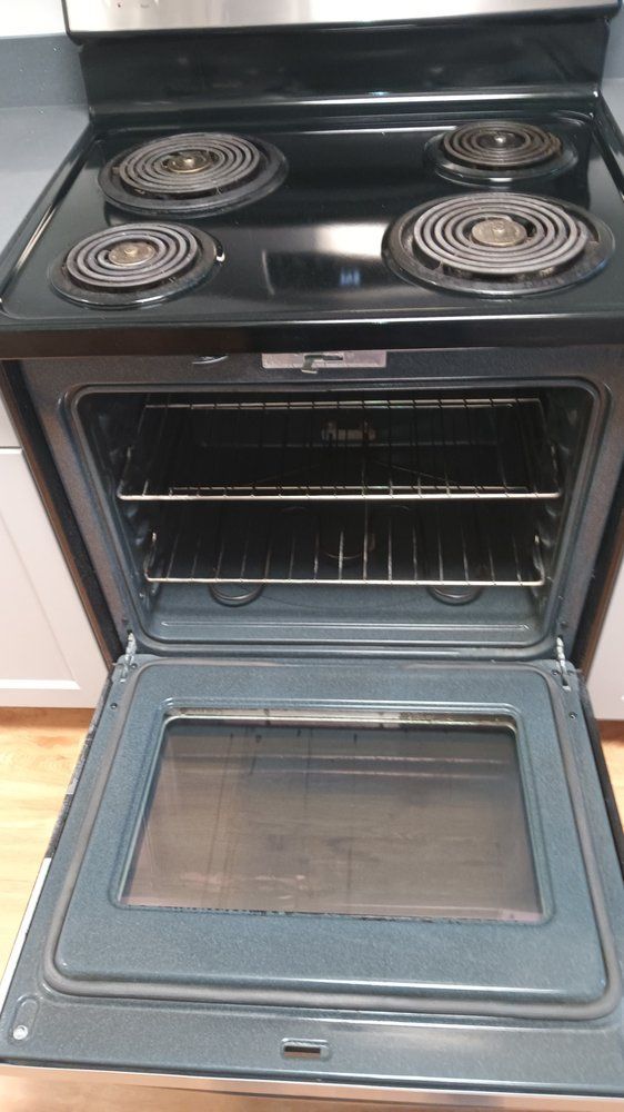 A black stove top oven with the door open in a kitchen.