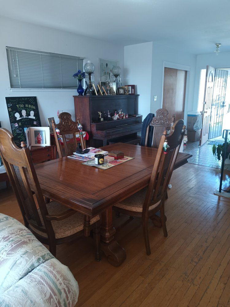 A dining room table and chairs in a living room.