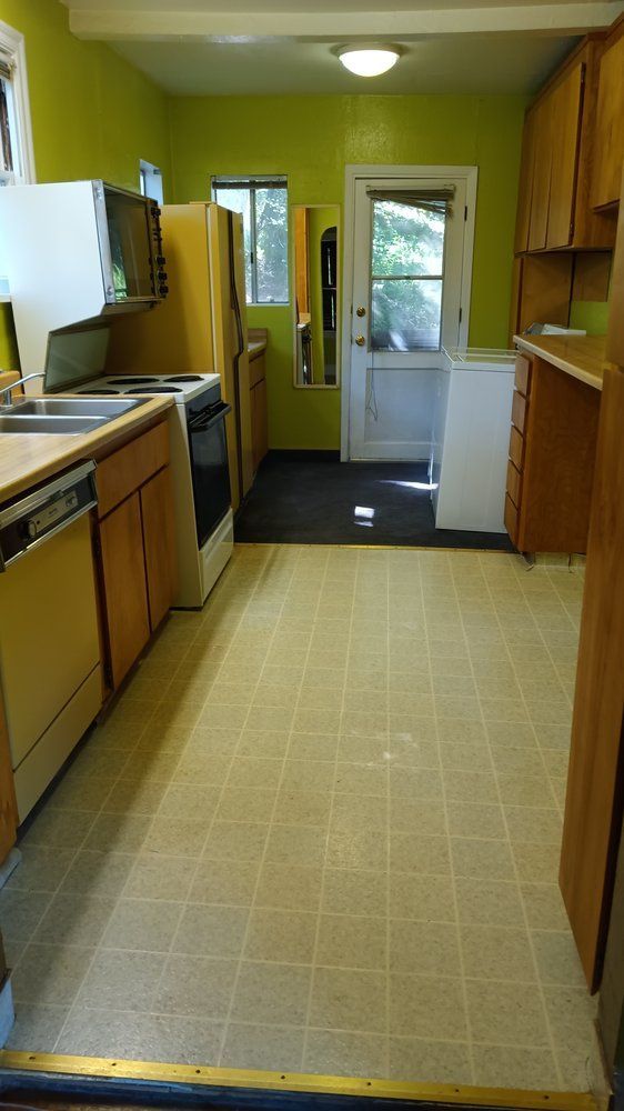 A kitchen with a stove , dishwasher , refrigerator and sink.
