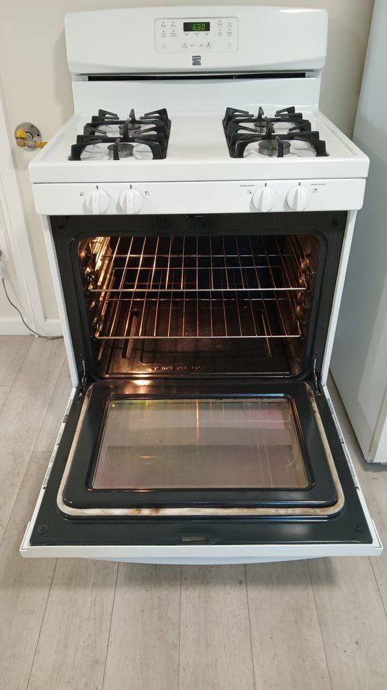 A white gas stove with the door open in a kitchen.
